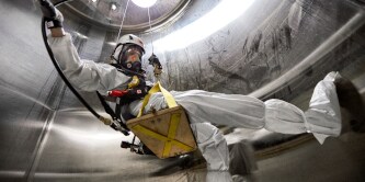 Firefighter cleaning tanks wearing scba equipment
