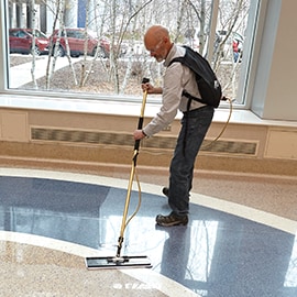A male worker applying 3M™ Scotchgard™ Stone Floor Protector on the tiled floors