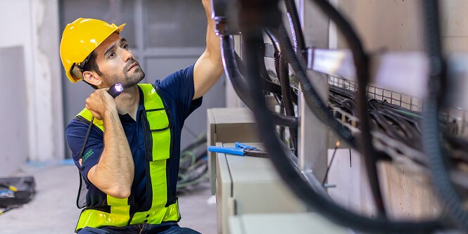 worker inspecting electrical cables
