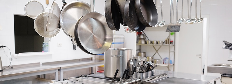 Hero image of a clean kitchen with hanging pots and pans