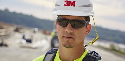 Image of a worker wearing a hard hat secured to his full body harness with a tether
