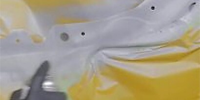 Screenshot of a video showing the application of primer to bare metal surfaces where adhesive will be applied
