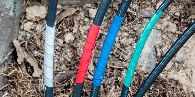 multiple electrical cables wrapped in various color coded electrical tape
