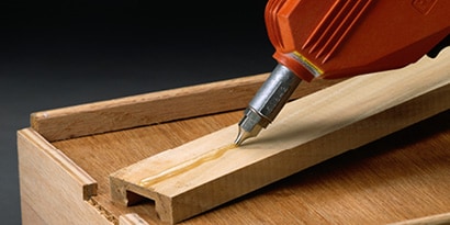 Liquid adhesive being applied to wood
