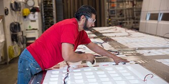A man using tape to attach wires and parts 
