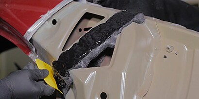 Screenshot of a video showing the reattachment of existing foam by using an NVH Dampening Material
