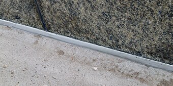 Sealed expansion joint between two materials that may expand and contract at different rates

