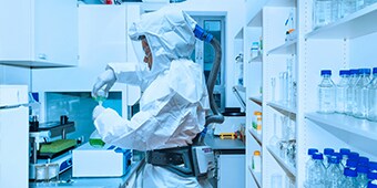 Worker in lab wearing 3M Versaflo PAPR
