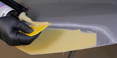 Screenshot of a video showing the application of the filler within the sanded area
